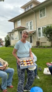 Woman holding a tray of treats during a break in the garden.