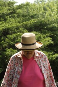 Modern photo of a gardener wearing a floppy gardening hat.